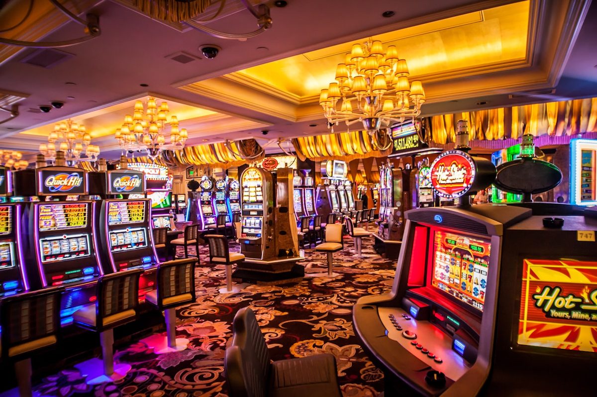 Suasana ruang permainan kasino dengan deretan mesin slot
